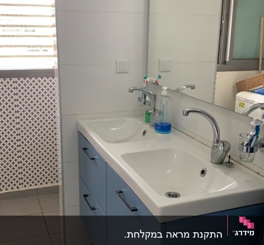 שני כיורים עם ברזים על ארון אמבטיה כחול